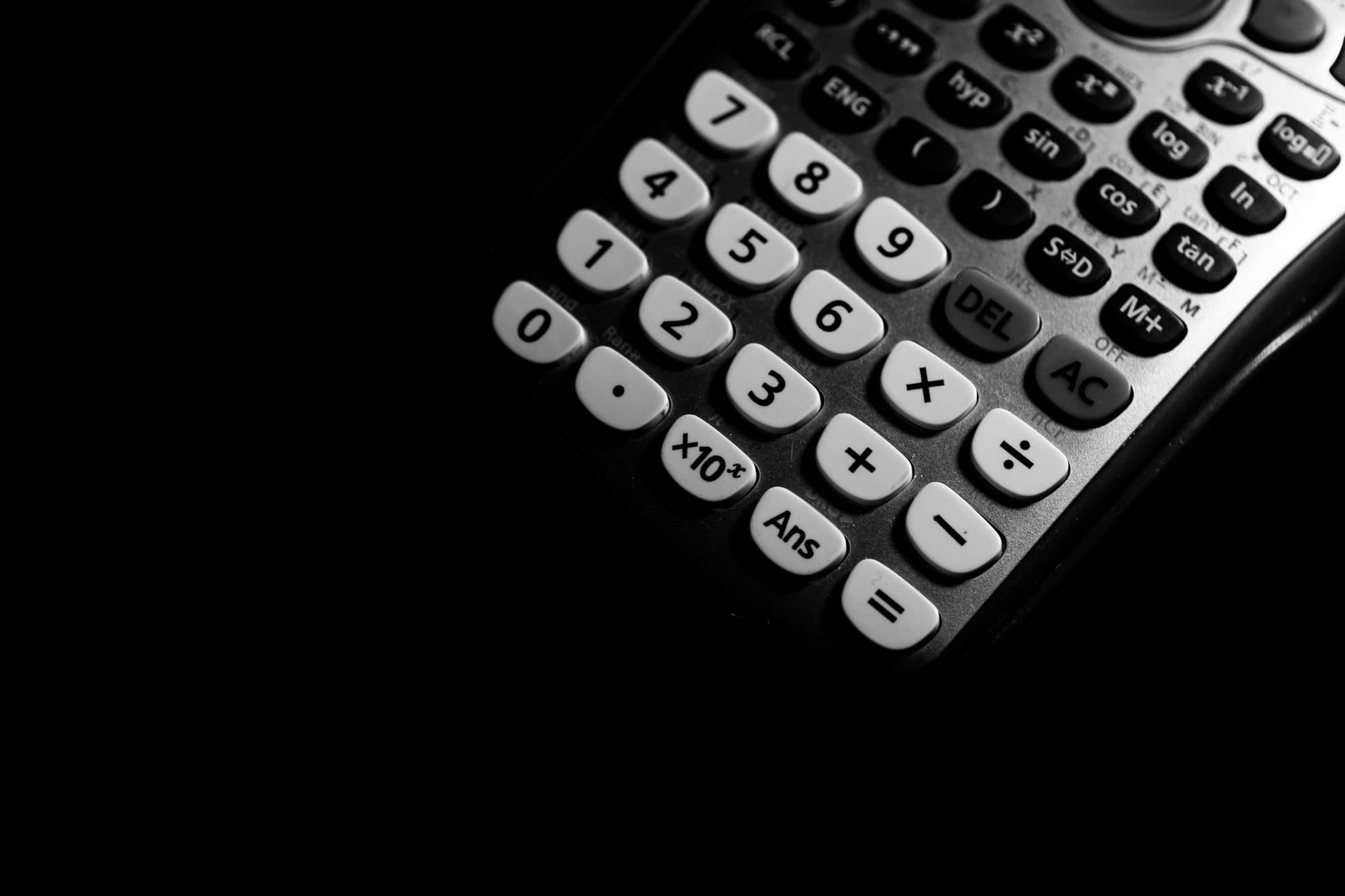 Close-up of a calculator keypad in dramatic black and white light