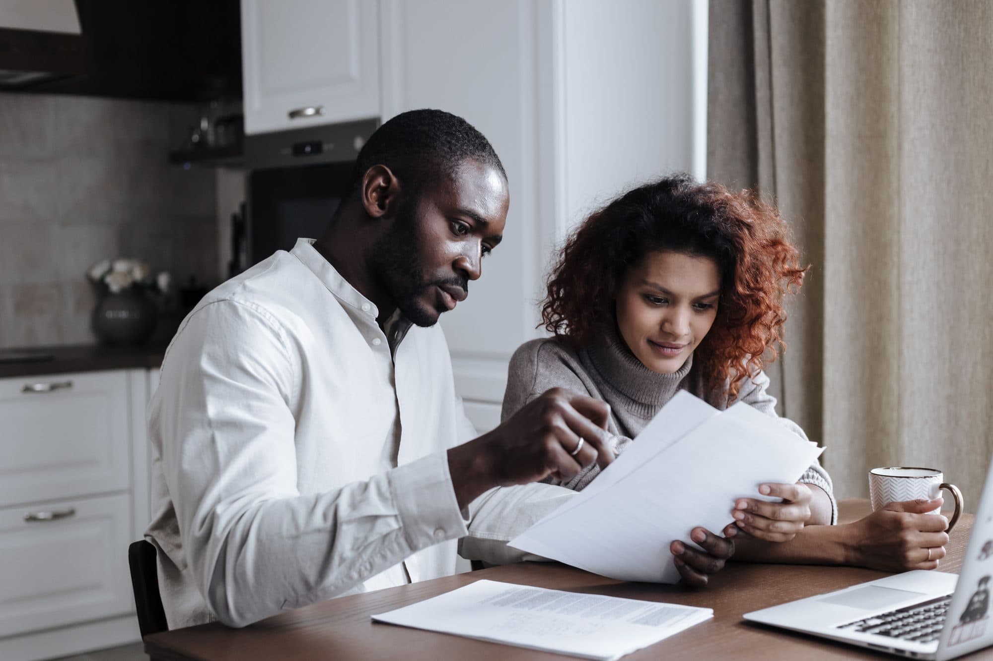 A couple reviewing their household paperwork together at home